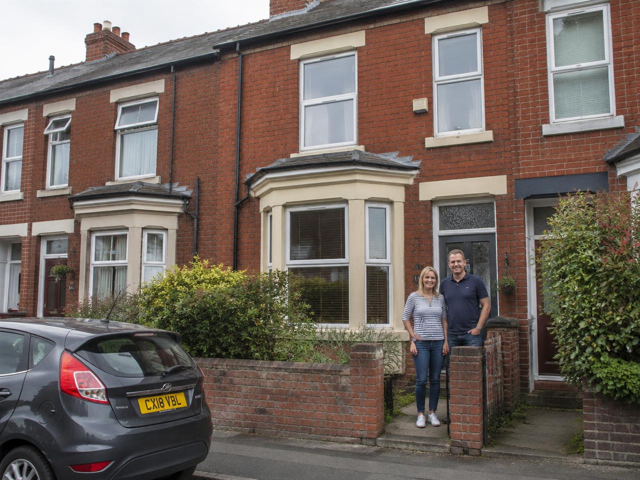 Illustrative happy homeowners in a bright clean kitchen